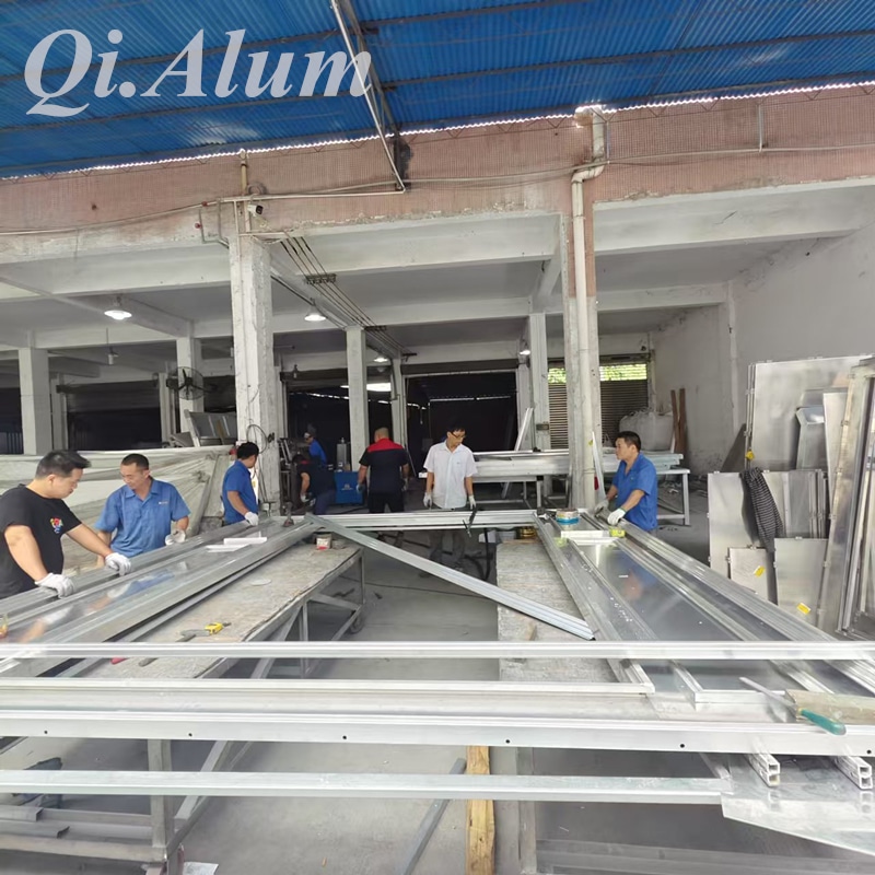 Custom curved aluminum window frames under fabrication for Thailand commercial project.